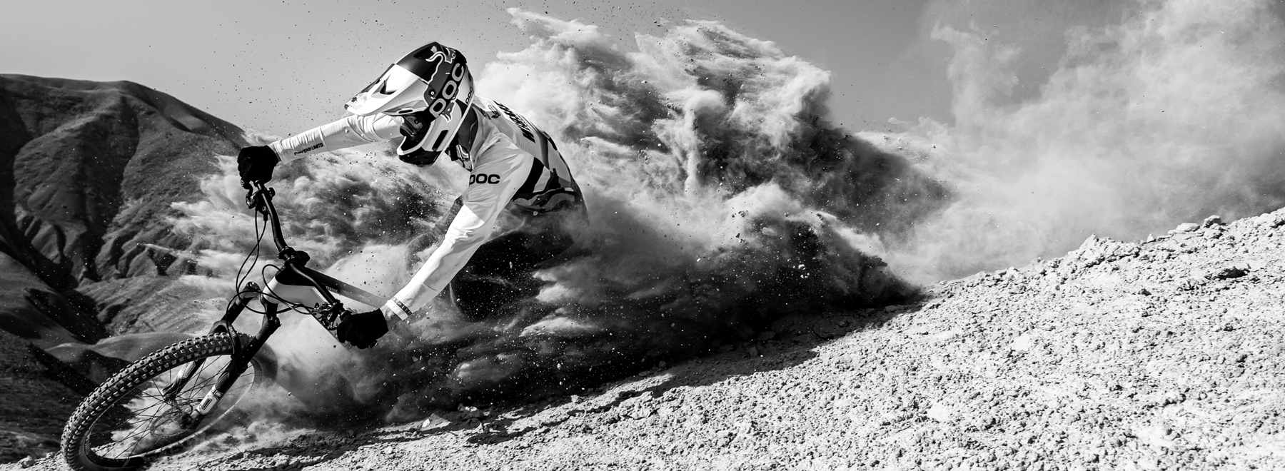 Fabio Wibmer riding down a mountain on a bike, stirring up dirt.