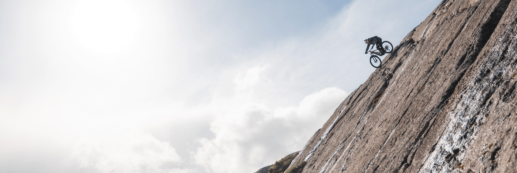 Danny MacAskill rides down a steep mountain on a bike.